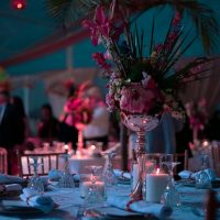 a table with a vase of flowers and candles on it