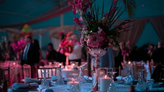 a table with a vase of flowers and candles on it