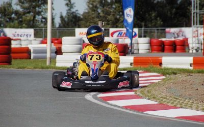 Pilote de kart en virage, portant le numéro 73, sur un circuit de course automobile