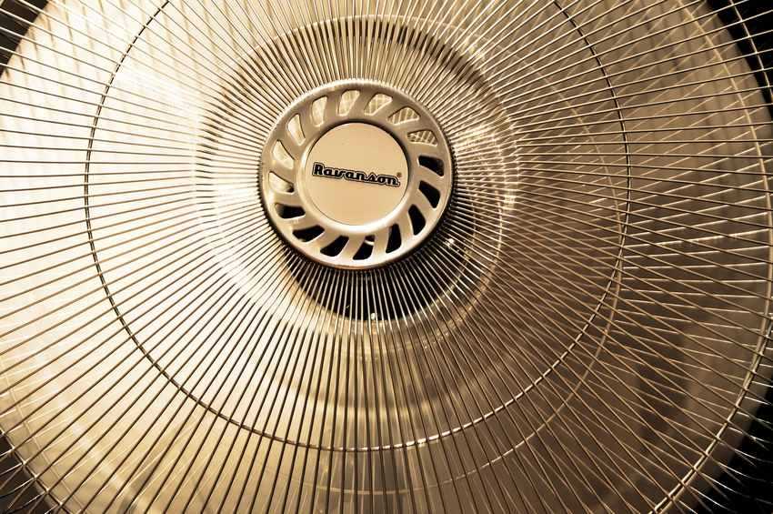 Vue rapprochée d'un ventilateur métallique à grille circulaire Vue rapprochée d'un ventilateur métallique à grille circulaire