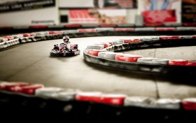 Un kart miniature tourne sur un circuit intérieur bordé de barrières
